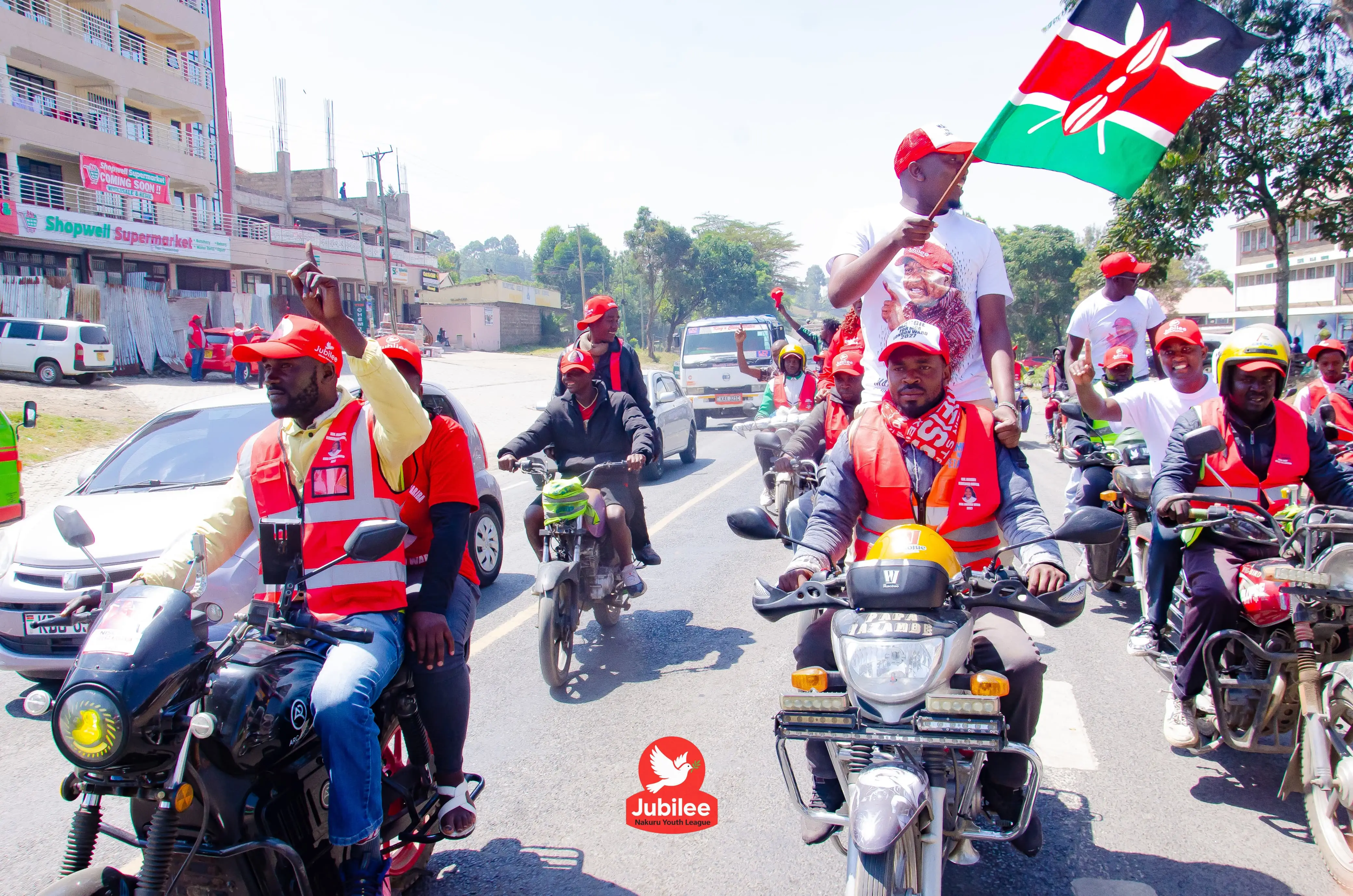 Boda boda convoy of riders in red with a Kenyan flag flying
