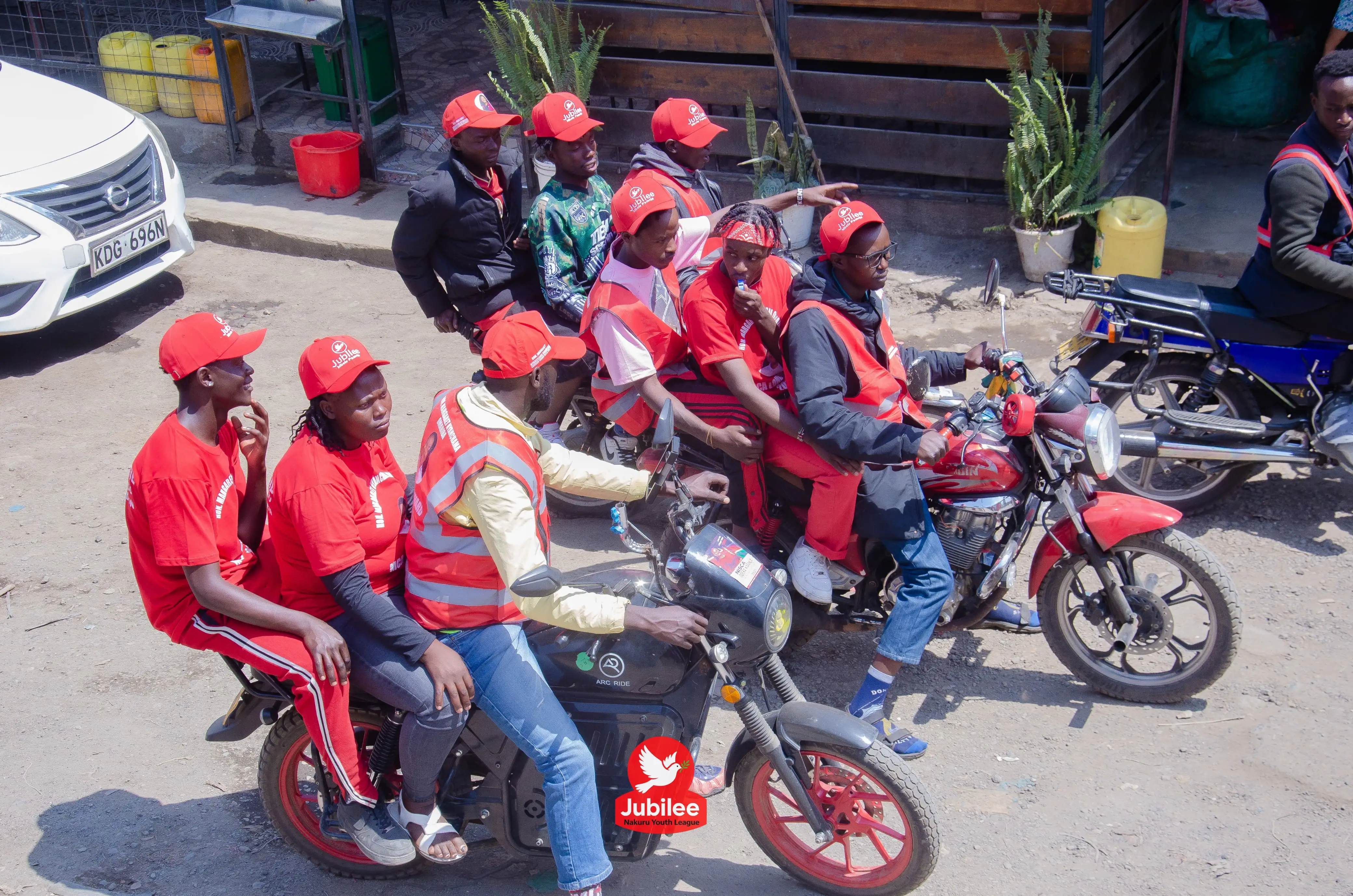 Group of riders in red jackets on motorbikes