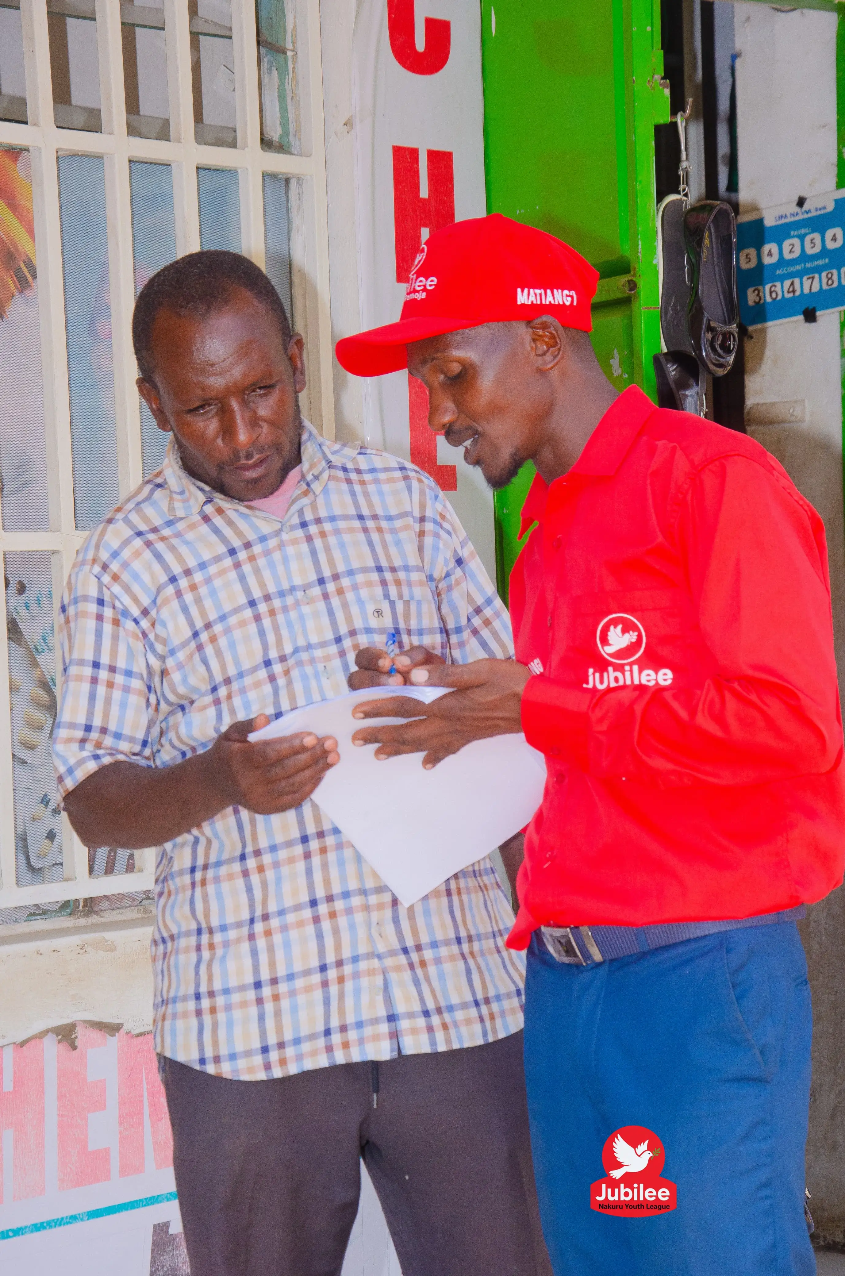 Volunteer in red explaining a flyer to a resident
