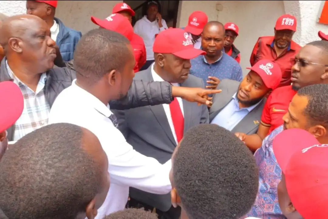 Dr Fred Matiang'i surrounded by supporters in red caps