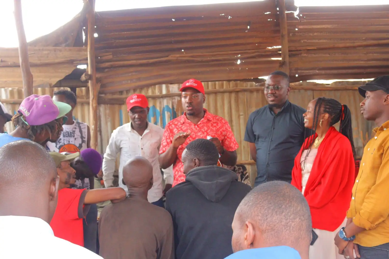 Team members in red caps meeting residents in a market